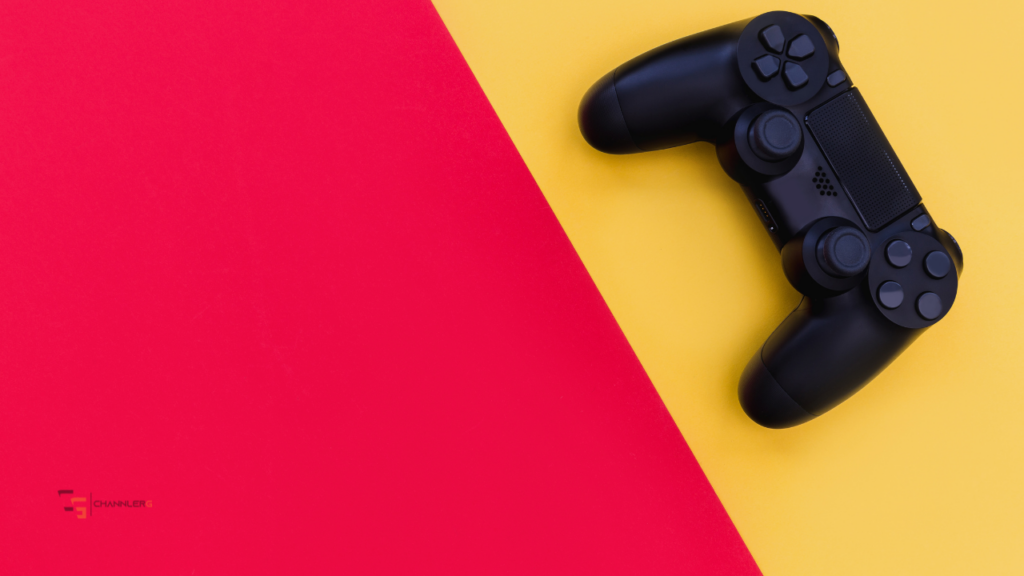 Black gaming controller on a bright red and yellow background.