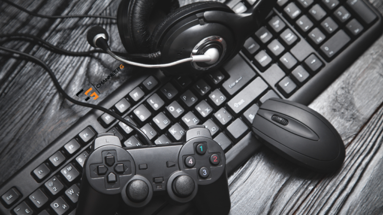 Gaming setup with controller, headset, keyboard, and mouse on a wooden desk.