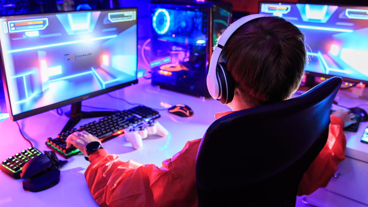 Person wearing headphones gaming at a dual-monitor setup with RGB lighting and PC tower.