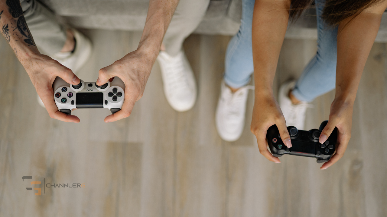 Two people holding gaming controllers while playing a video game together from a top-down view.
