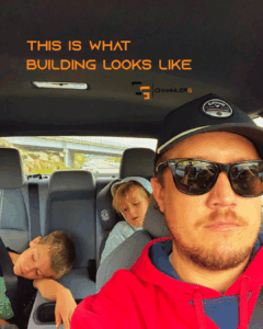 Father driving with two young boys asleep in the back seat after a real estate sign install.
