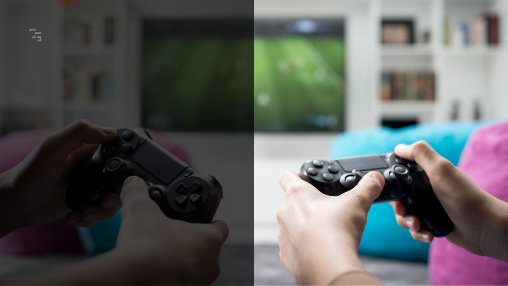 Two people playing a soccer video game on a TV while holding PlayStation-style controllers in a living room gaming setup.