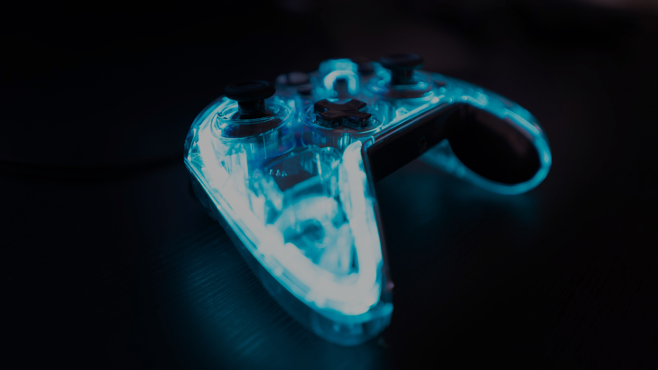 Close-up of a glowing translucent gaming controller on a dark background