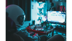 Person in astronaut helmet gaming in a neon-lit room with collectibles and a glowing TV screen