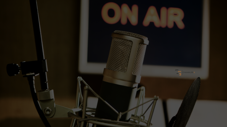 Close-up of a professional podcast microphone with a blurred “On Air” sign in the background