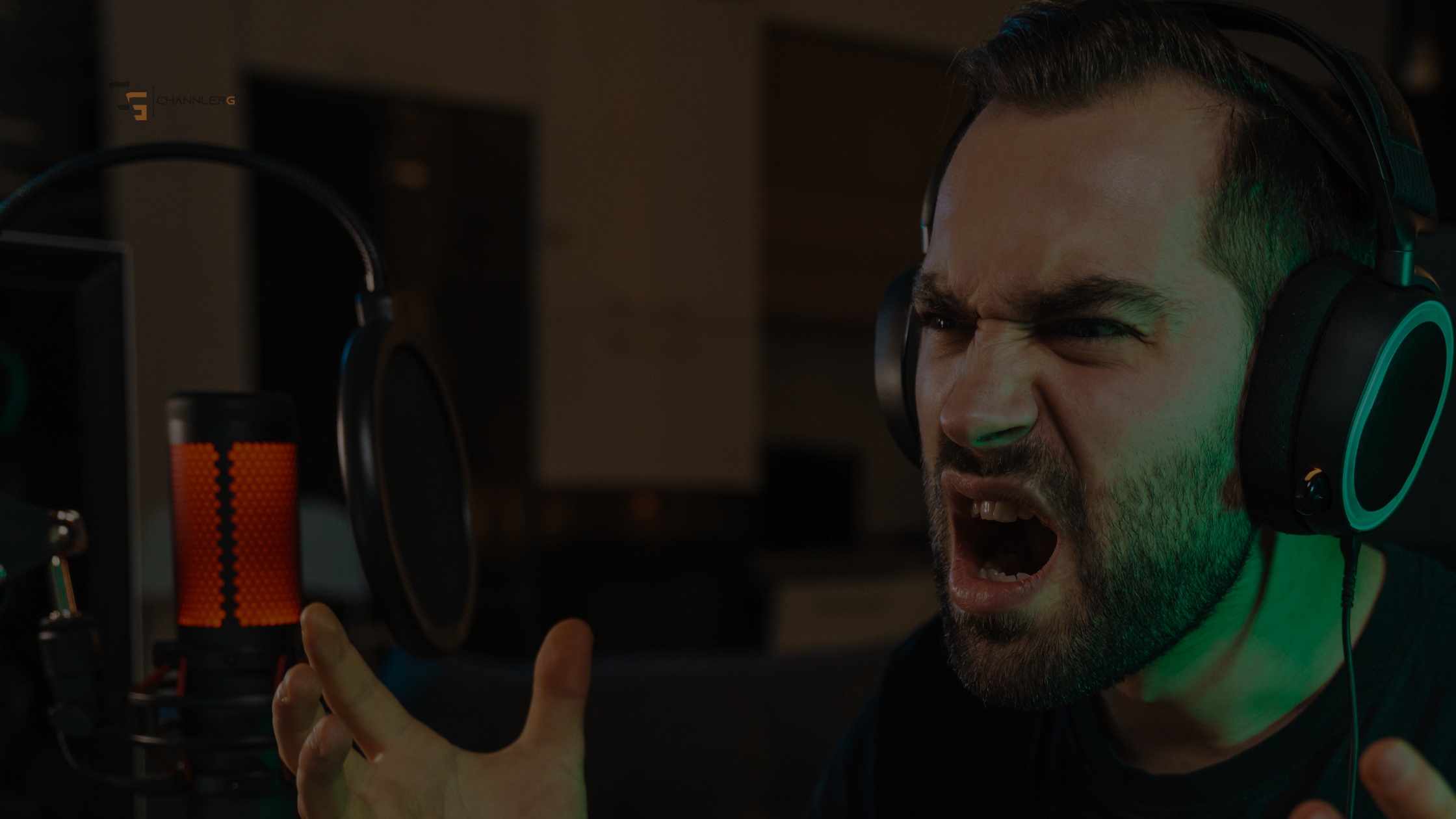 Frustrated gamer yelling into a headset while streaming with a red-lit microphone in front of him.