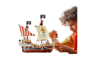 Child playing with LEGO One Piece The Going Merry pirate ship and Luffy minifigure.
