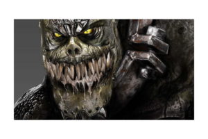 Close-up of Killer Croc from Batman: Arkham Asylum, showing his glowing yellow eyes, sharp teeth, reptilian skin, and metal restraints.