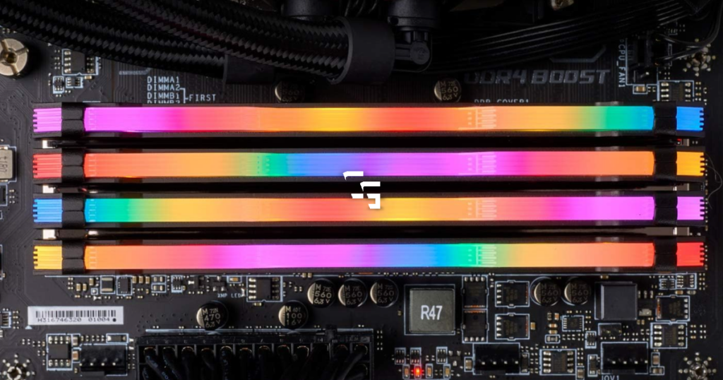 Four RGB RAM sticks installed on a gaming PC motherboard with colorful lighting in pink, blue, green, and orange